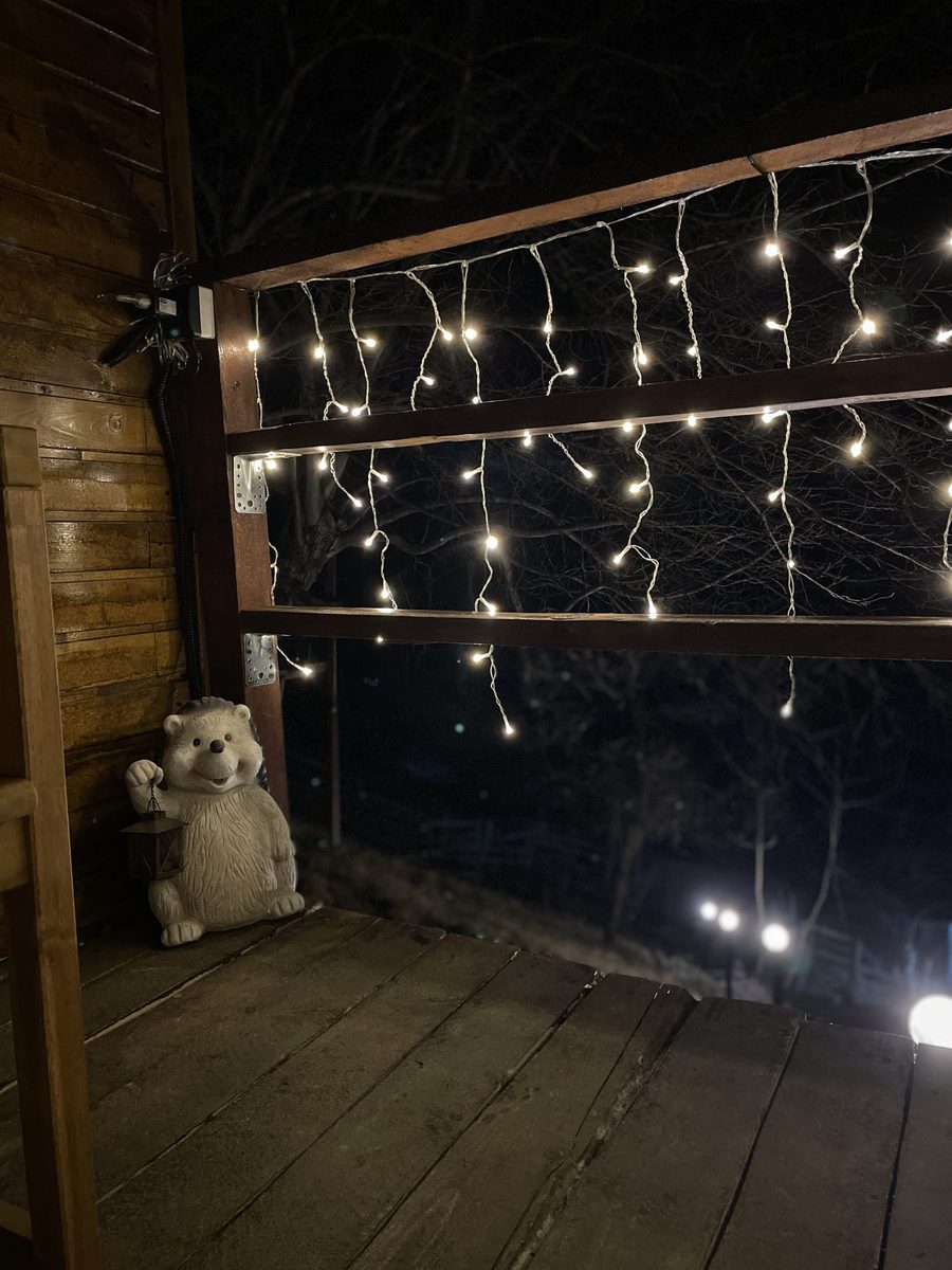 Sculptura arici cu lanterna pe terasa luminată noaptea