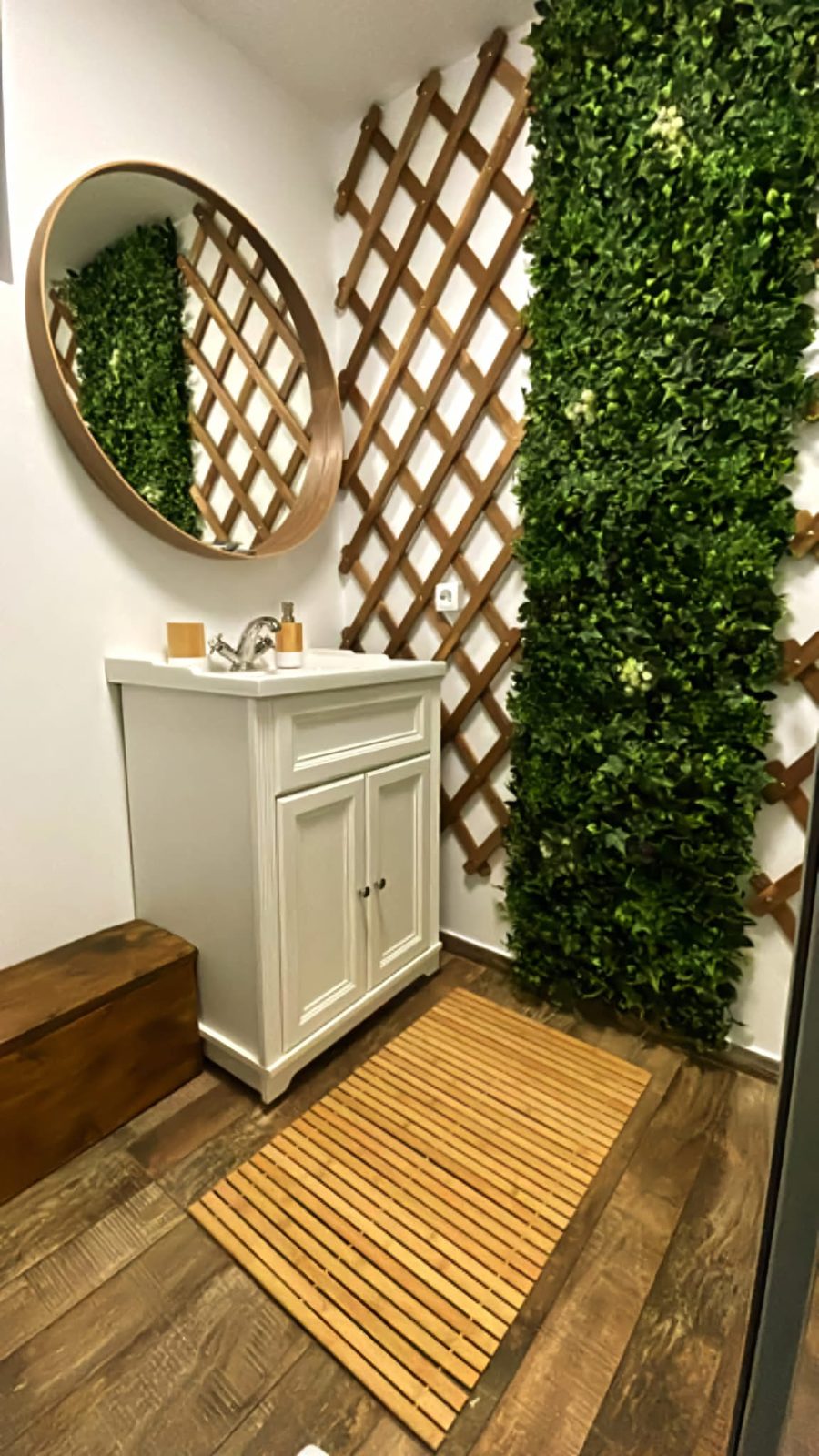 Baie cu chiuveta clasică, oglindă rotundă și perete vegetal