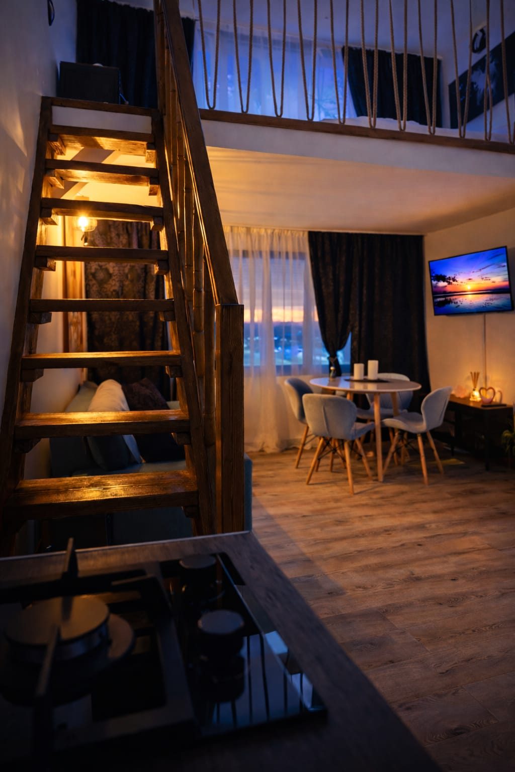 Interior cabană cu apus prin geam, lumini calde