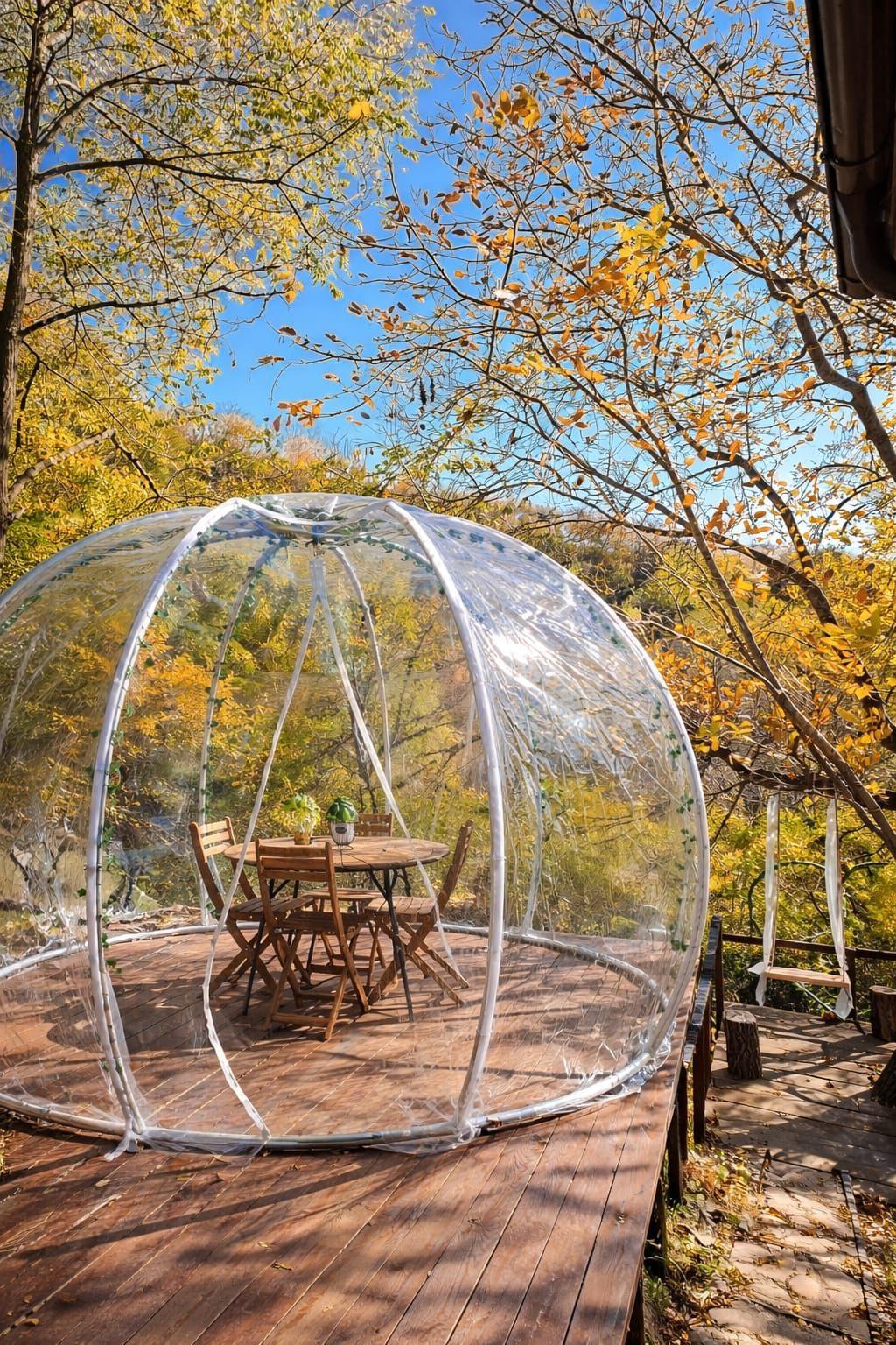 Terasa igloo cu masă rotundă sub copacii cu frunze toamna